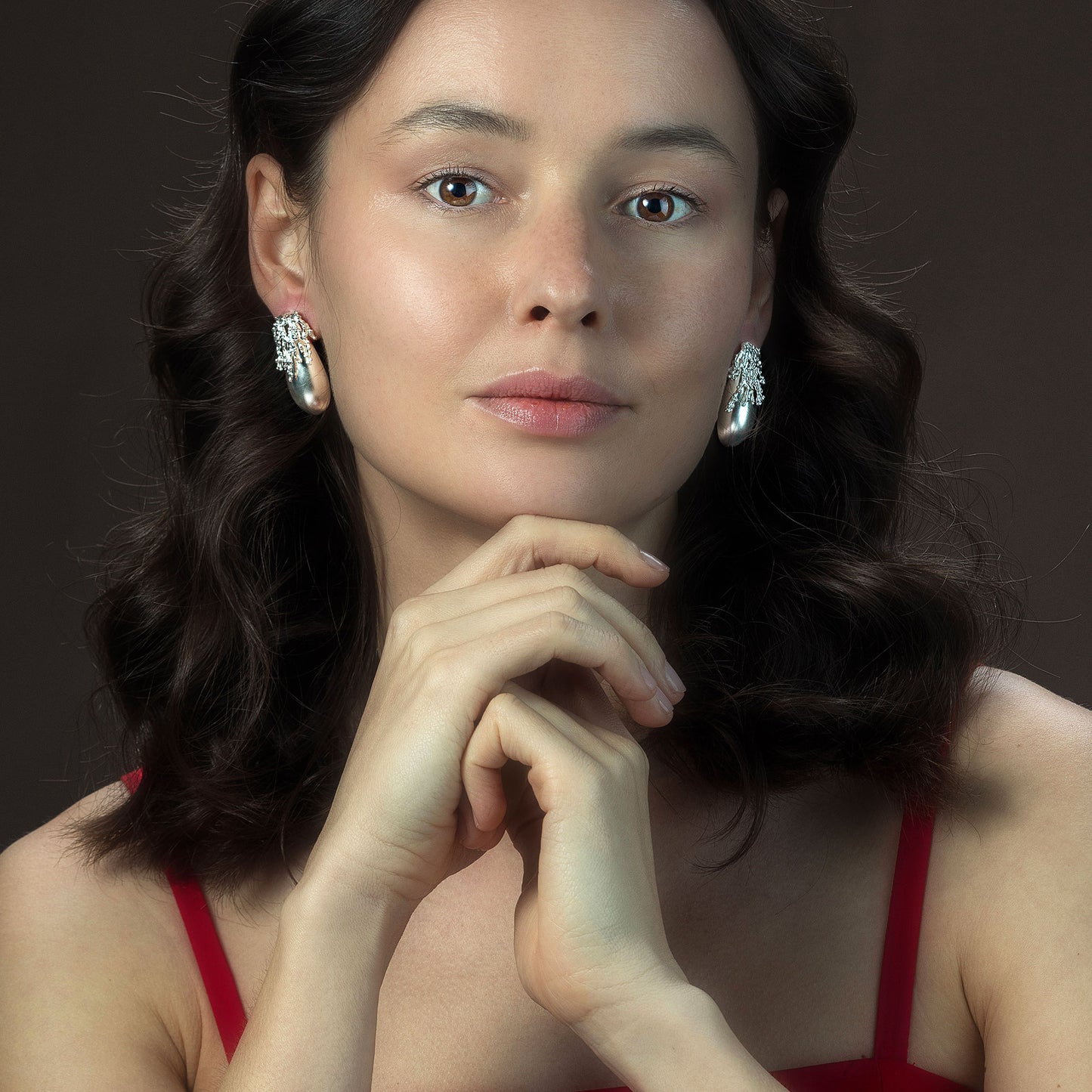 Model wearing Rawan Kanan handcrafted matte 925 sterling silver drop earrings with organic textured crown.