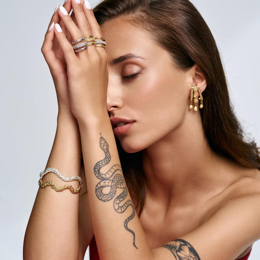Model wearing Rawan Kanan handcrafted triple branch statement earrings in 14K gold plated silver.