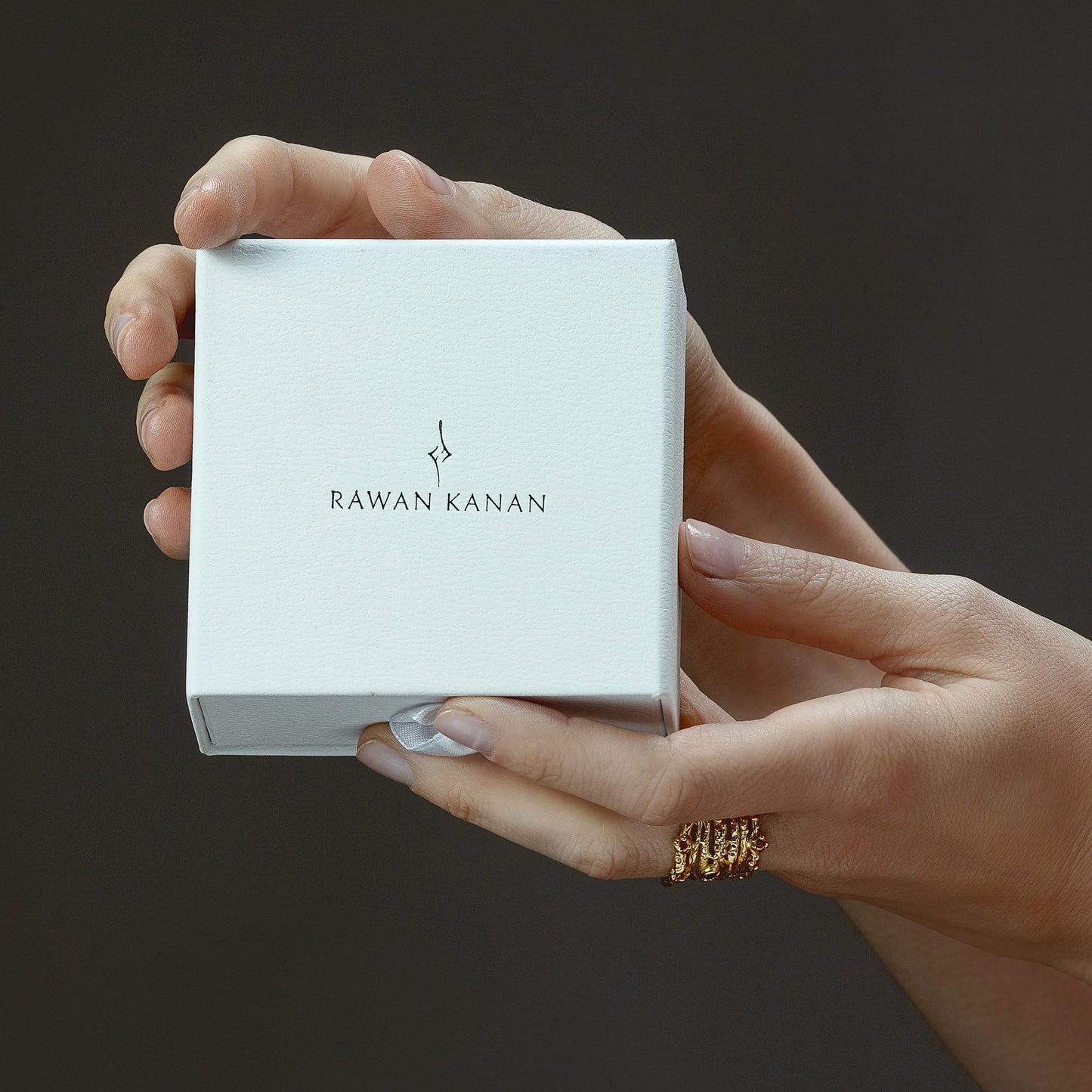 Model wearing Rawan Kanan handcrafted two-tone heart stud earrings in 925 silver and textured 14K gold frame.