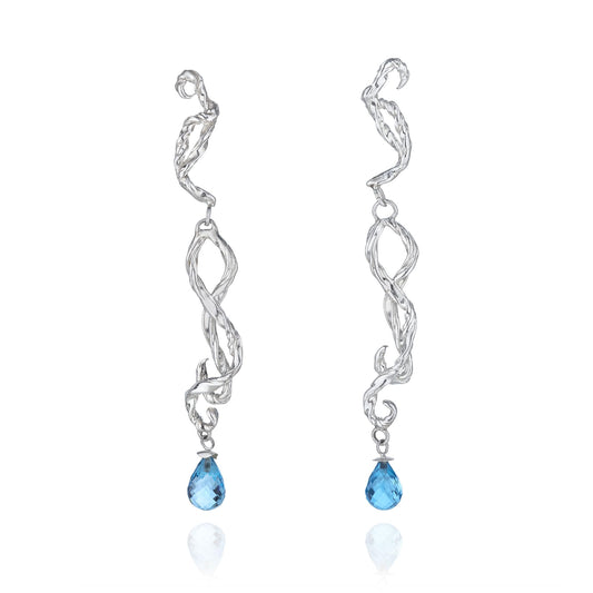 Artisan 925 sterling silver intertwining drop earrings by Rawan Kanan set with faceted blue topaz gemstones.